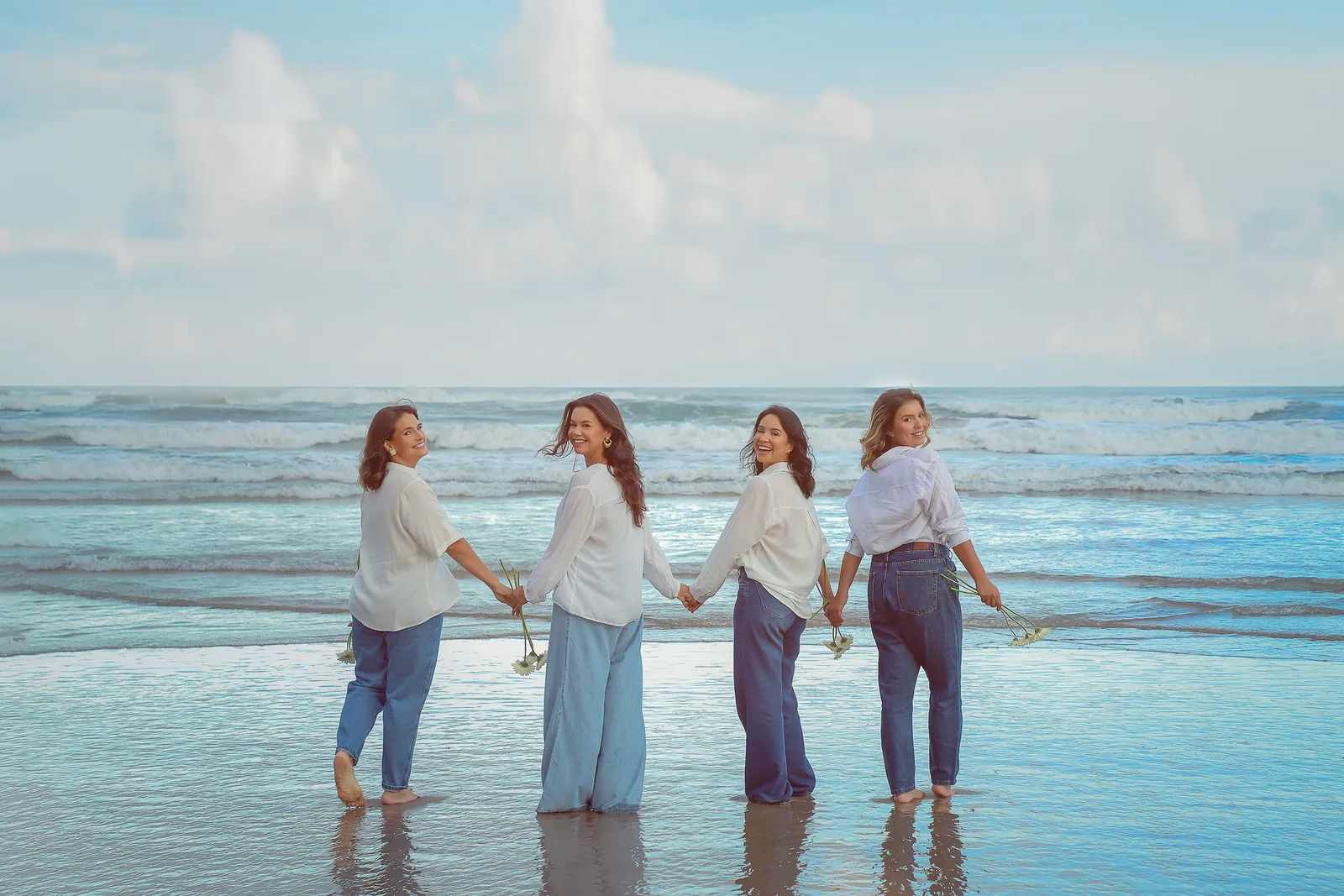 As quatro mulheres do Movimento Betel de mãos dadas na beira do mar